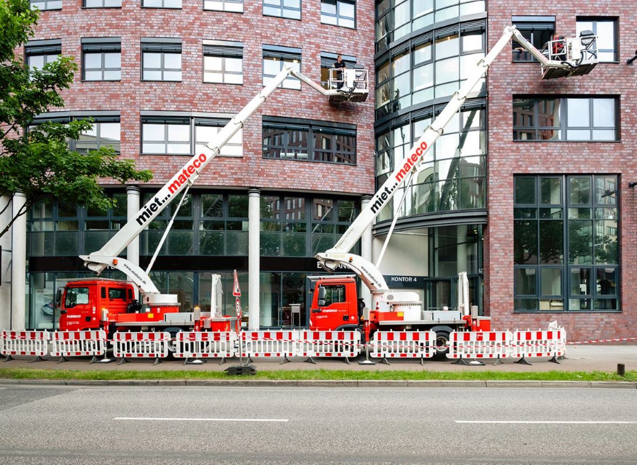 Rote LKW-Arbeitsbühnen mit Straßenabsperrung