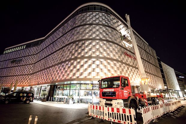 Rote LKW-Arbeitsbühne mit Straßenabsperrung bei Nacht